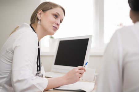 Lekarka prowadząca konsultację z pacjentem w gabinecie, badanie i porada medyczna